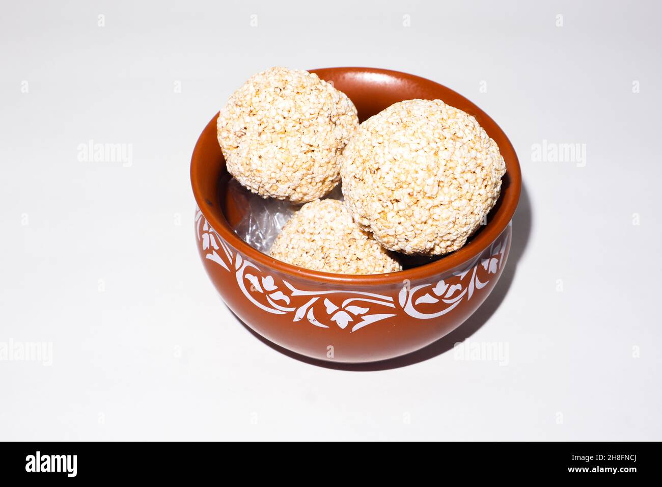Indische Süßigkeit für traditionelles Festival makar sankranti :Rajgira laddu aus Amaranth Samen in Schale auf weißem Hintergrund Stockfoto