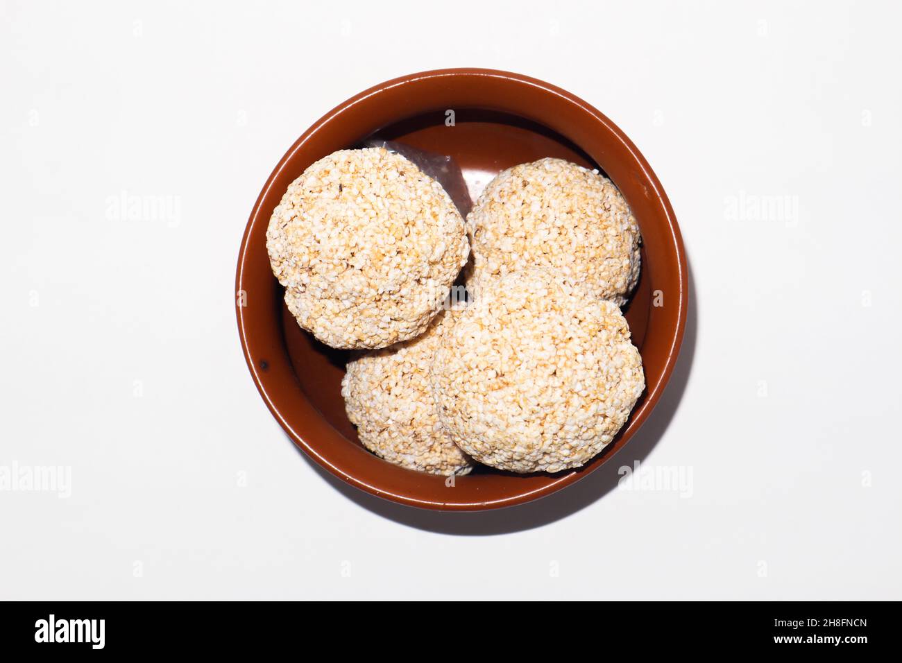 Indische Süßigkeit für traditionelles Festival makar sankranti :Rajgira laddu aus Amaranth Samen in Schale auf weißem Hintergrund Stockfoto