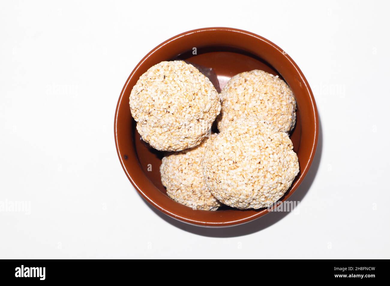 Indische Süßigkeit für traditionelles Festival makar sankranti :Rajgira laddu aus Amaranth Samen in Schale auf weißem Hintergrund Stockfoto