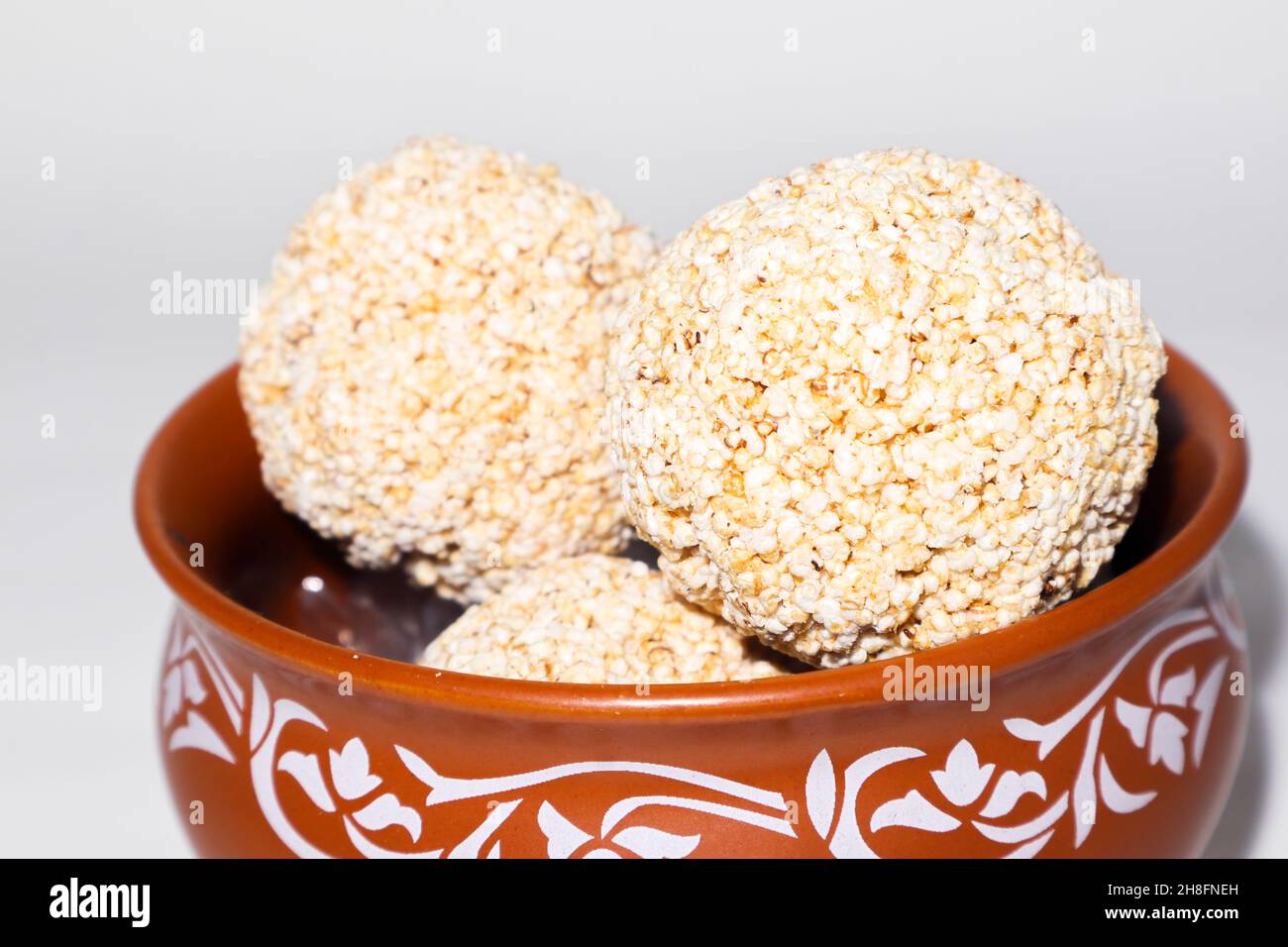Indische Süßigkeit für traditionelles Festival makar sankranti :Rajgira laddu aus Amaranth Samen in Schale auf weißem Hintergrund Stockfoto