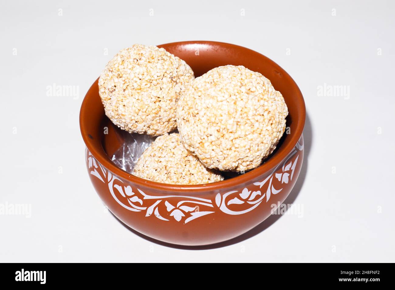 Indische Süßigkeit für traditionelles Festival makar sankranti :Rajgira laddu aus Amaranth Samen in Schale auf weißem Hintergrund Stockfoto