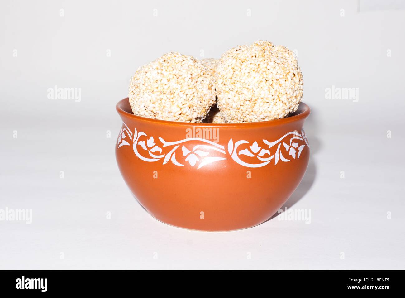 Indische Süßigkeit für traditionelles Festival makar sankranti :Rajgira laddu aus Amaranth Samen in Schale auf weißem Hintergrund Stockfoto