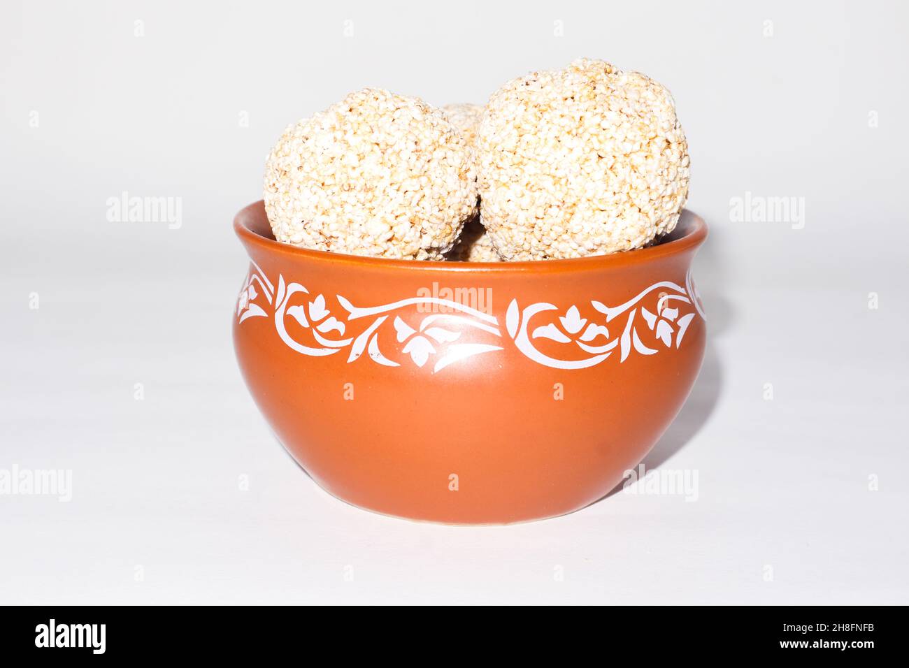 Indische Süßigkeit für traditionelles Festival makar sankranti :Rajgira laddu aus Amaranth Samen in Schale auf weißem Hintergrund Stockfoto