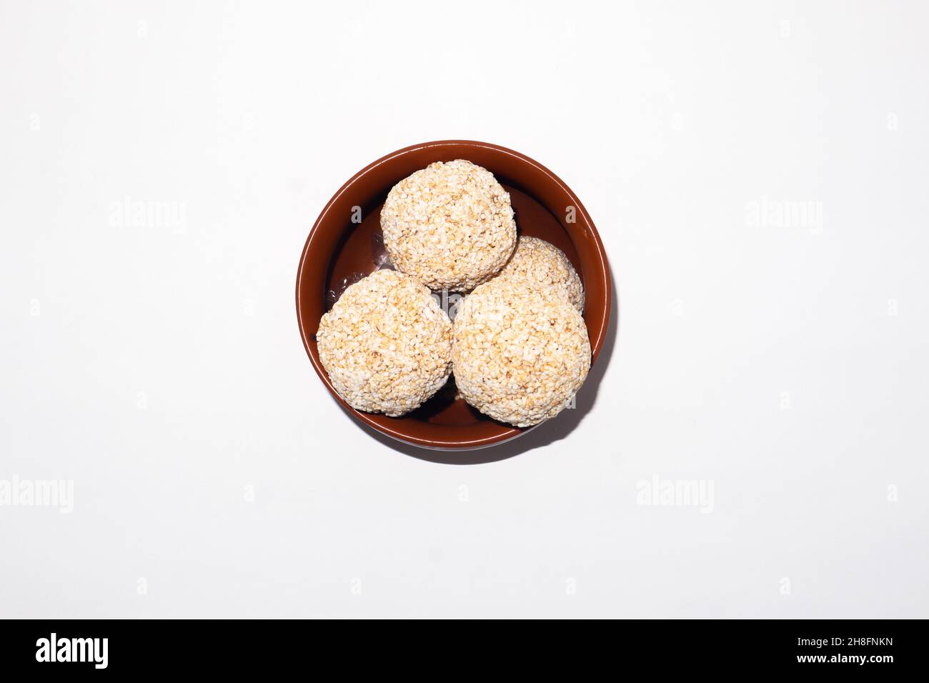 Indische Süßigkeit für traditionelles Festival makar sankranti :Rajgira laddu aus Amaranth Samen in Schale auf weißem Hintergrund Stockfoto