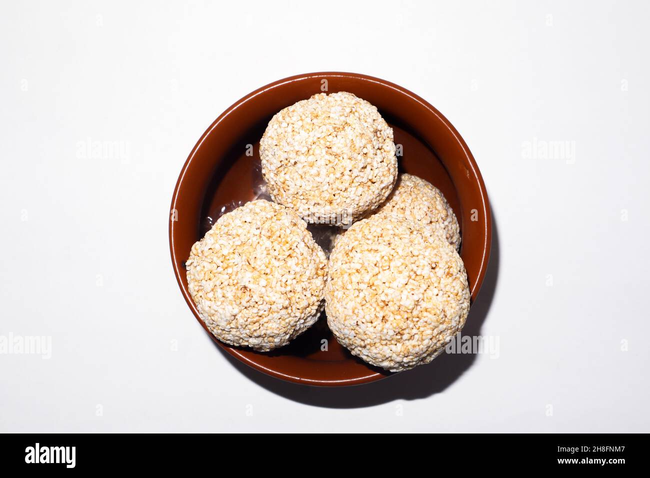 Indische Süßigkeit für traditionelles Festival makar sankranti :Rajgira laddu aus Amaranth Samen in Schale auf weißem Hintergrund Stockfoto