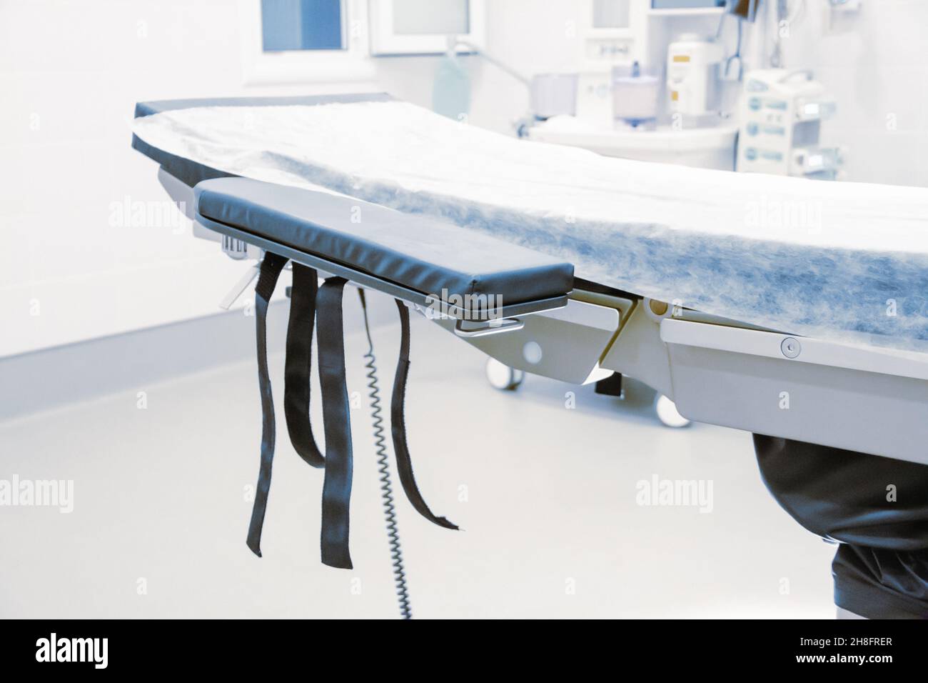 Leerer Operationssaal in einem Krankenhaus. Chirurgische Ausrüstung mit Operationstisch. Medizinisches Gerät für Notfallpatienten im Blauton-Stil. Leerer Notfall Stockfoto