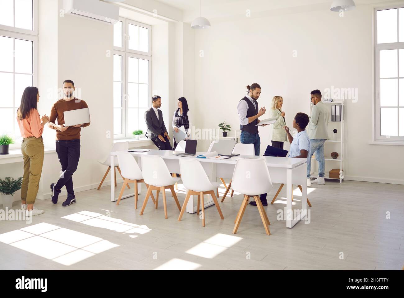 Gruppen von Arbeitskollegen kommunizieren und diskutieren verschiedene Arbeitsmomente am modernen Arbeitsplatz. Stockfoto