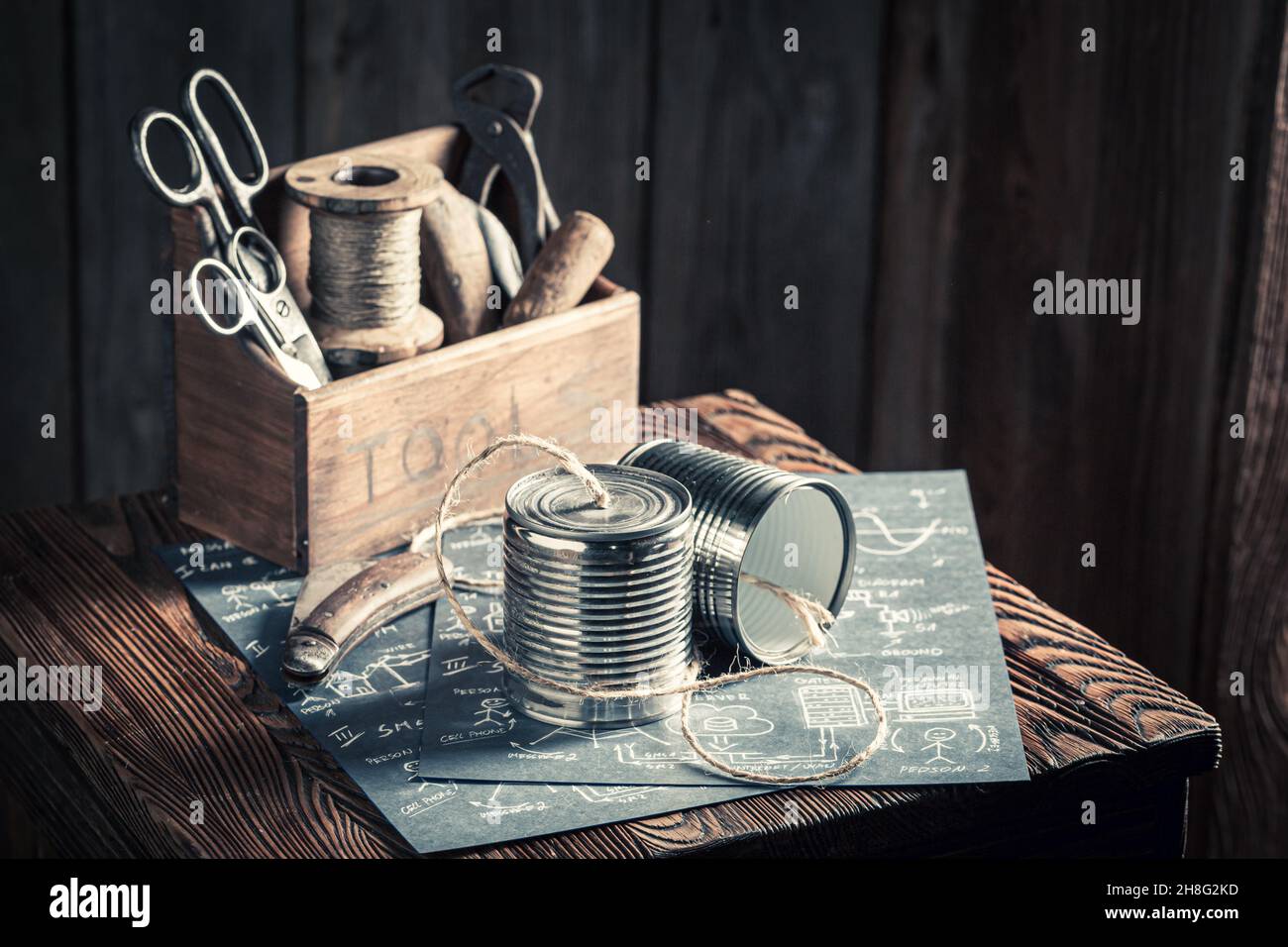 Vintage-Telefon aus String und Dosen als Kommunikationskonzept. Blaue Retro-Skizze. Stockfoto
