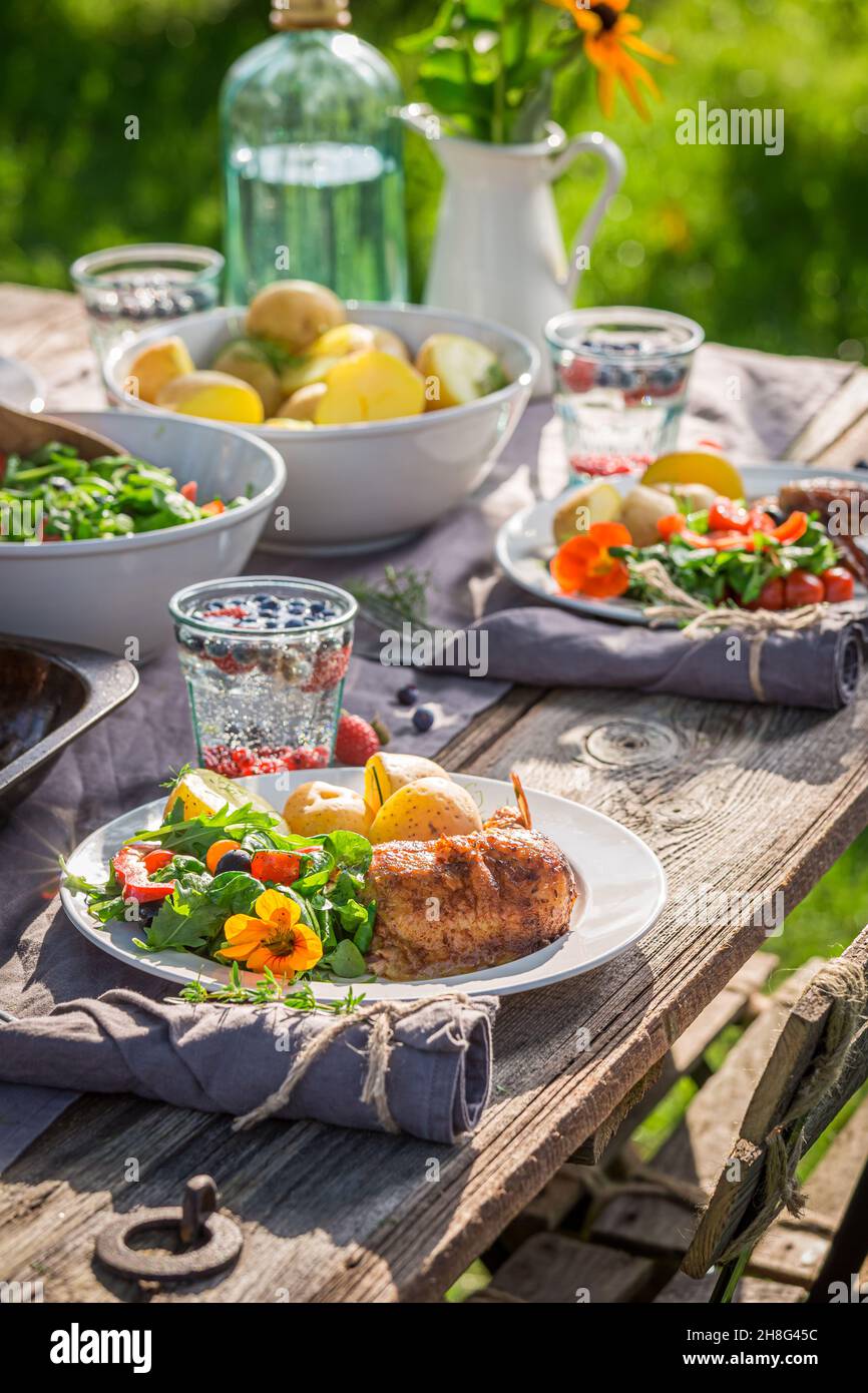 Hausgemachtes Abendessen mit Huhn im Garten serviert. Huhn zum Abendessen. Hausgemachtes Abendessen auf dem Land. Stockfoto