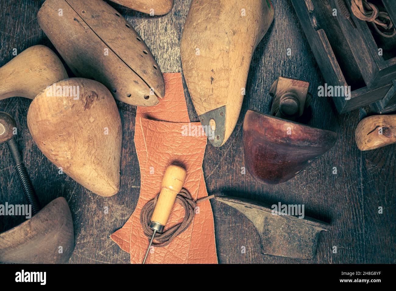 Kleine Schuhmacherwerkstatt mit Werkzeugen, Schnürsenkeln und Schuhen. Kleine Schuhmacherwerkstatt Stockfoto