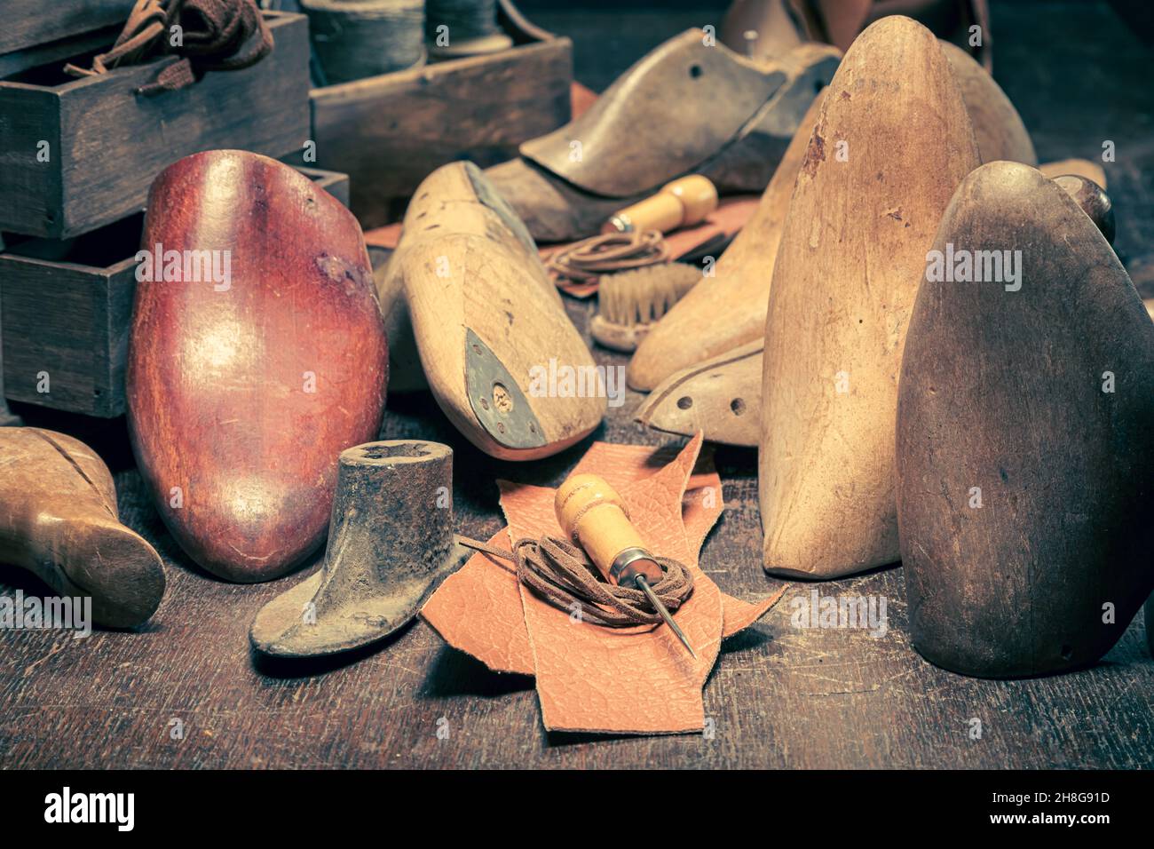 Vintage Schuster Arbeitsplatz mit Werkzeugen, Regeln, Leder und Riemen. Vintage Schuster Arbeitsplatz Stockfoto