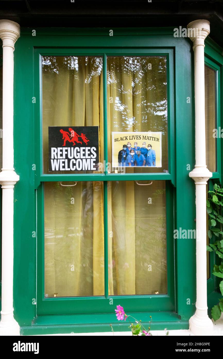 FLÜCHTLINGE WILLKOMMEN Zeichen und SCHWARZE LEBEN MATERIE Display in einem Fenster vor einem Haus in Walthamstow London E17 England Großbritannien KATHY DEWITT 2021 Stockfoto