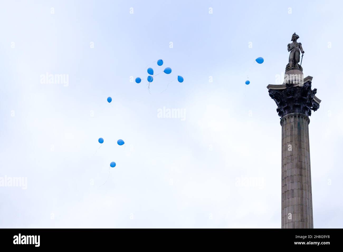 Lose Heliumballons schweben an Nelson's Column vorbei Stockfoto