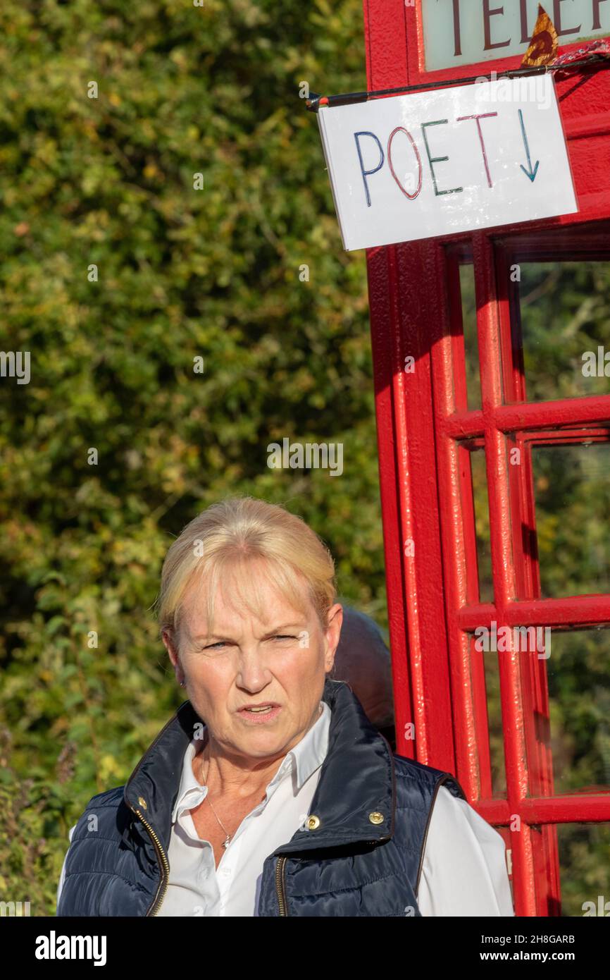 Auf dem Great Glemham Mini Poetry Festival eine Frau unter einem Schild, das Dichter sagt Stockfoto