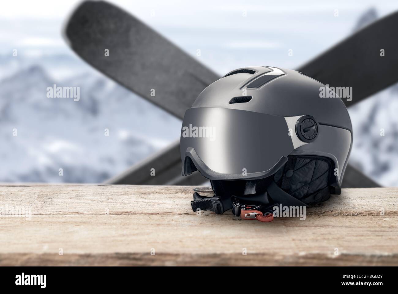 Skihelm mit Visier auf Berge Hintergrund. Moderner grauer Helm mit Sonnenblende auf Berge Hintergrund. Wintersport-Helm. Mountain Resort. Kopie Stockfoto