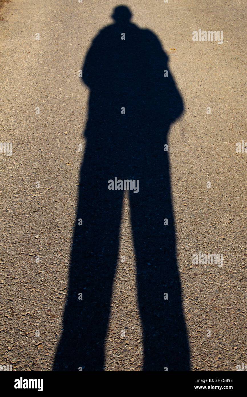 Großer menschlicher Schatten auf einer Straße Stockfoto