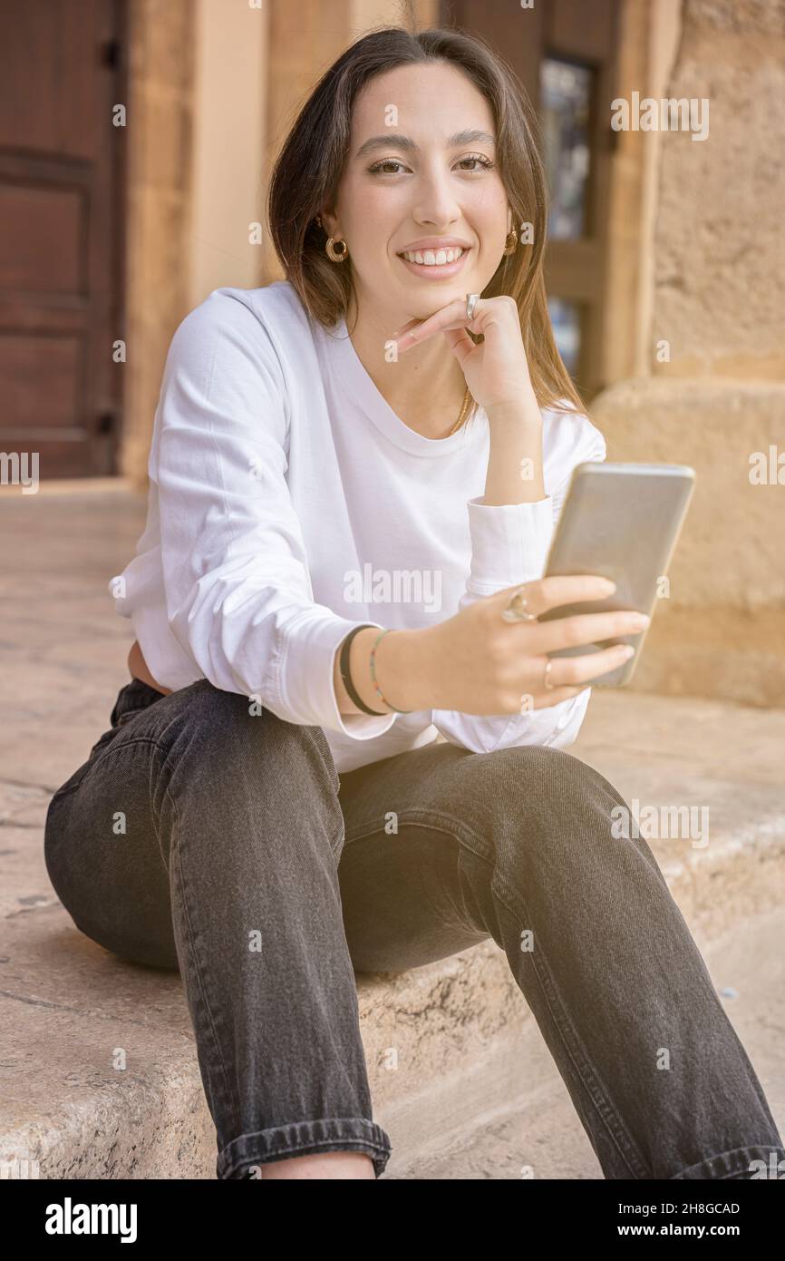 Junge Frau, die Kamera mit Mobiltelefon im Freien Stadtleben Stockfoto