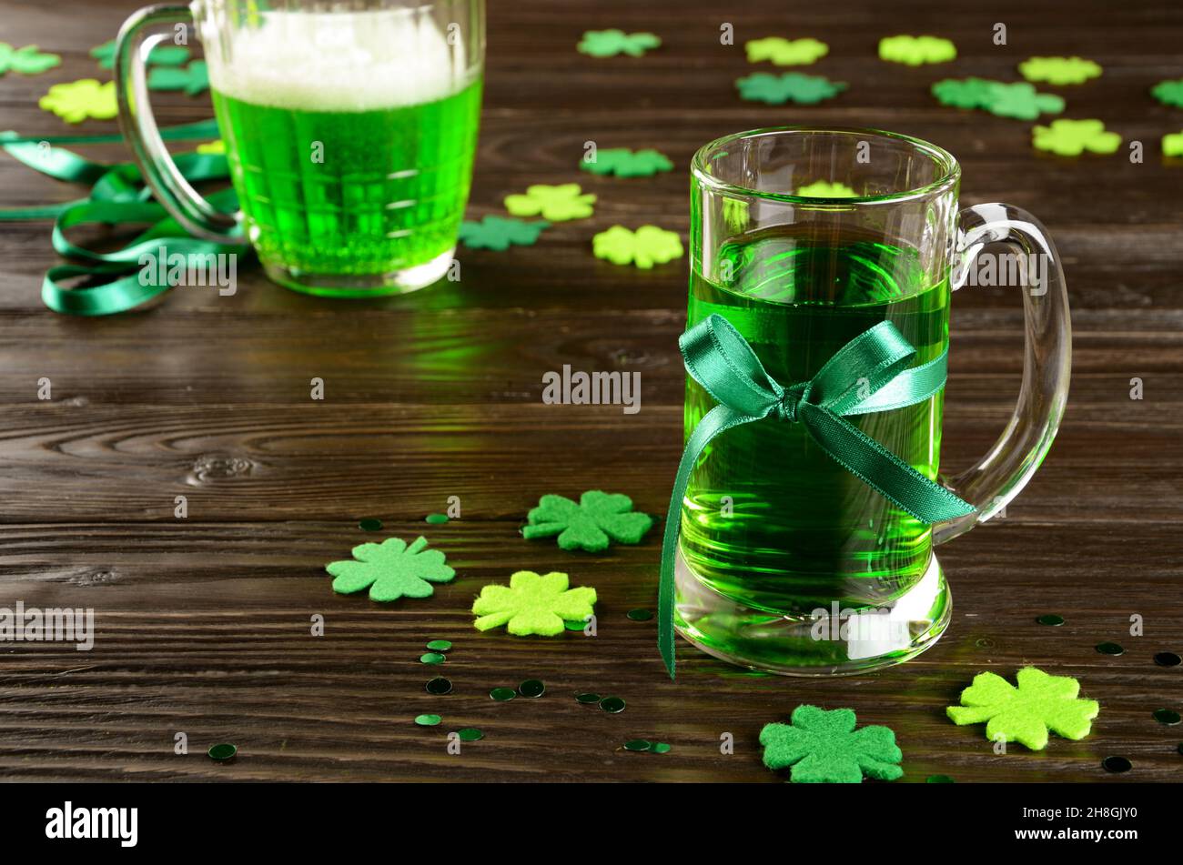 St. Patricks Tag mit einem Pint grünem Bier auf einem Holztisch mit handgemachten Filzshamrocks. Kopierbereich Stockfoto