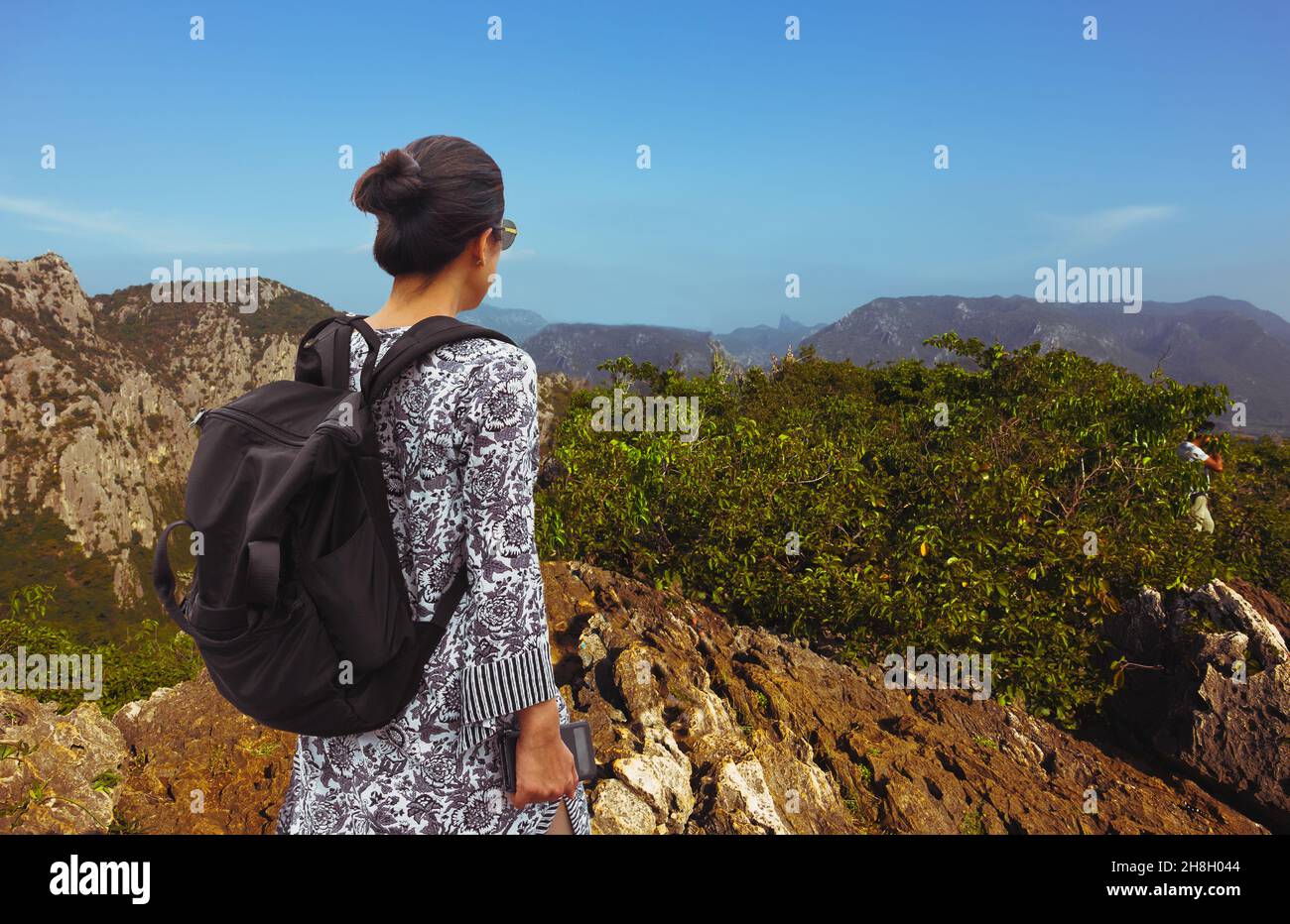 Frau, die mit einem Rucksack auf dem Berg steht. Stockfoto