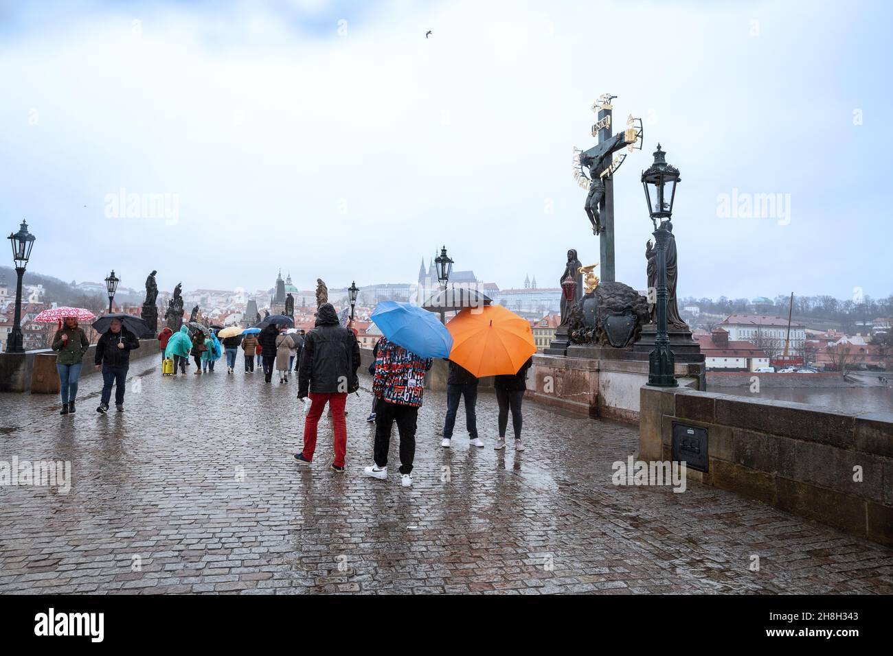 Prag - 11. März 2020: An einem regnerischen Tag wandern die Menschen über die Karlsbrücke Stockfoto