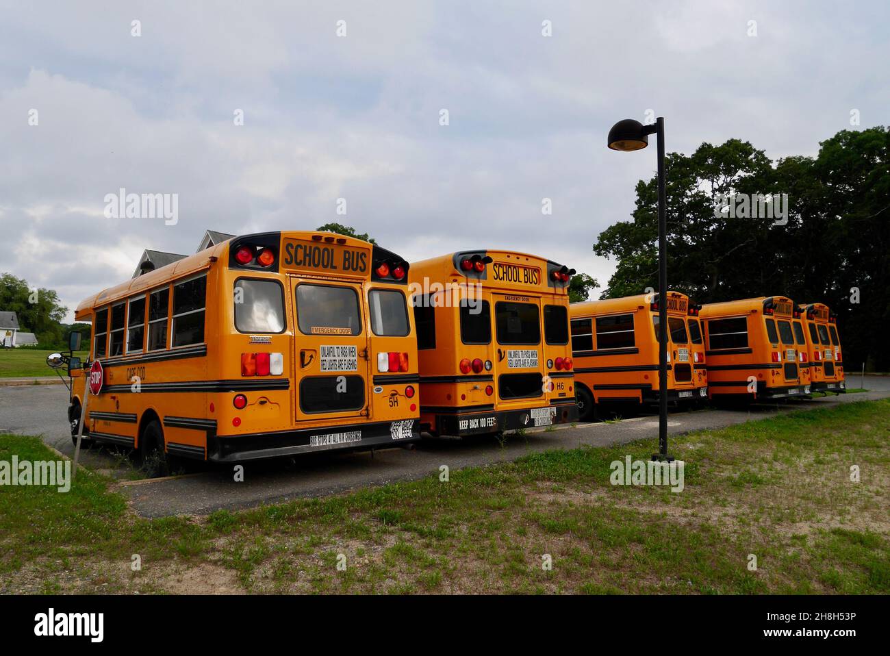 Reihe von gelben Schulbussen auf dem Parkplatz. Onset, Massachusetts, 23.07.2019. Stockfoto