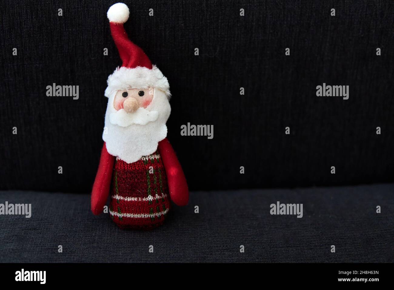 Dekorative Miniatur santa claus isoliert auf schwarzem Hintergrund in der Nacht. Weihnachtsschmuck und Postkarte. Weihnachten, Winter, Neujahr Konzept. Flach liegend Stockfoto