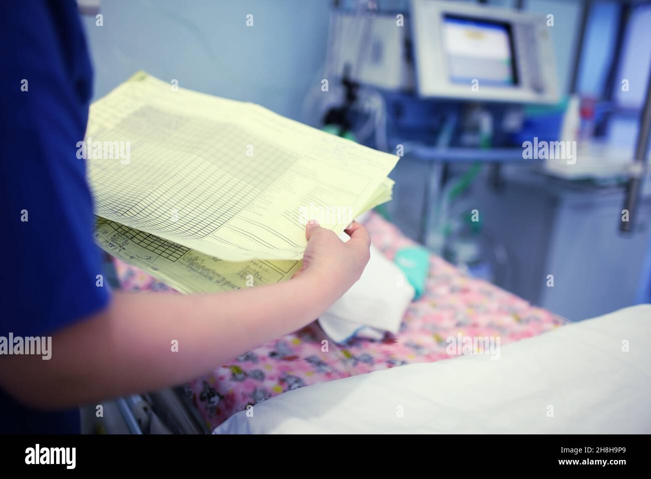 Ärztin, die auf die Krankenakte des Säuglings schaut. Stockfoto