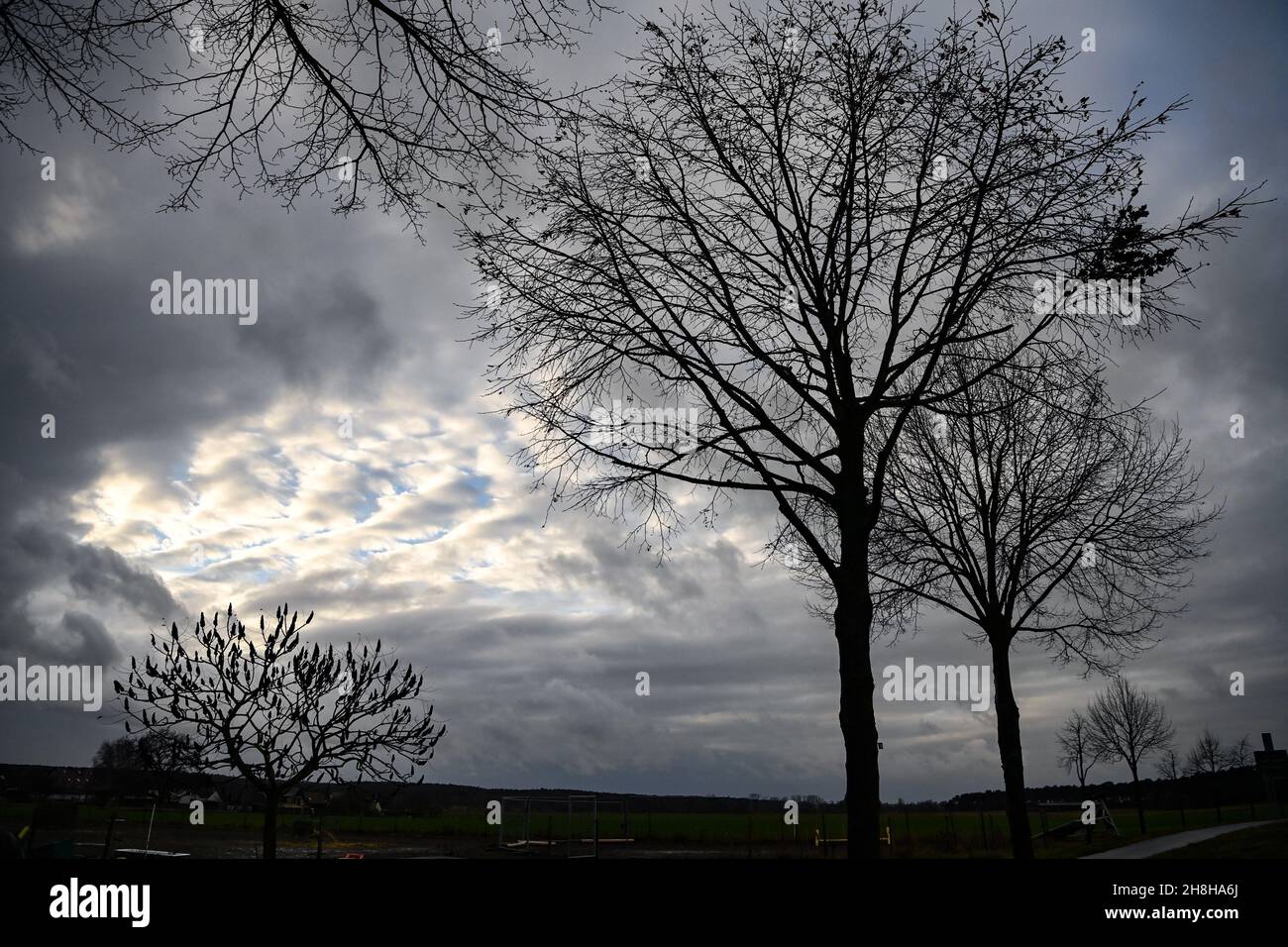 Zauchwitz, Deutschland. 30th. November 2021. Zwischen grauen Regenwolken über einem Feld zeigt sich nur eine kleine Lücke in den Wolken. Es wird erwartet, dass sich das kalte und regnerische Wetter in den nächsten Tagen fortsetzen wird, teilweise wird Schnee vorhergesagt. Quelle: Jens Kalaene/dpa-Zentralbild/ZB/dpa/Alamy Live News Stockfoto