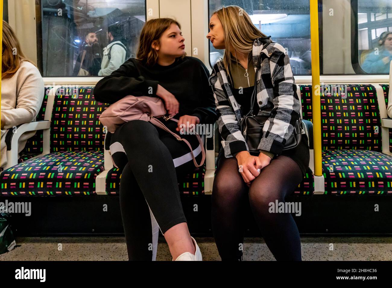 Zwei junge Frauen auf der Londoner U-Bahn, London, Großbritannien. Stockfoto