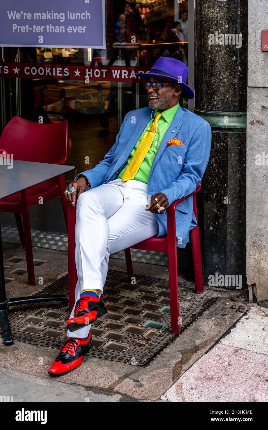 Ein gut gekleideter Mann, der vor Einem Café in der Marylebone High Street, London, Großbritannien, sitzt. Stockfoto