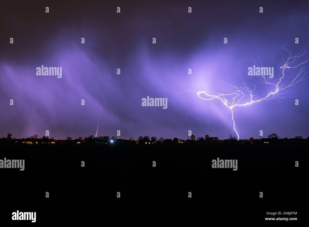 Heller verzweigter Blitz während eines herbstlichen Gewitters Stockfoto