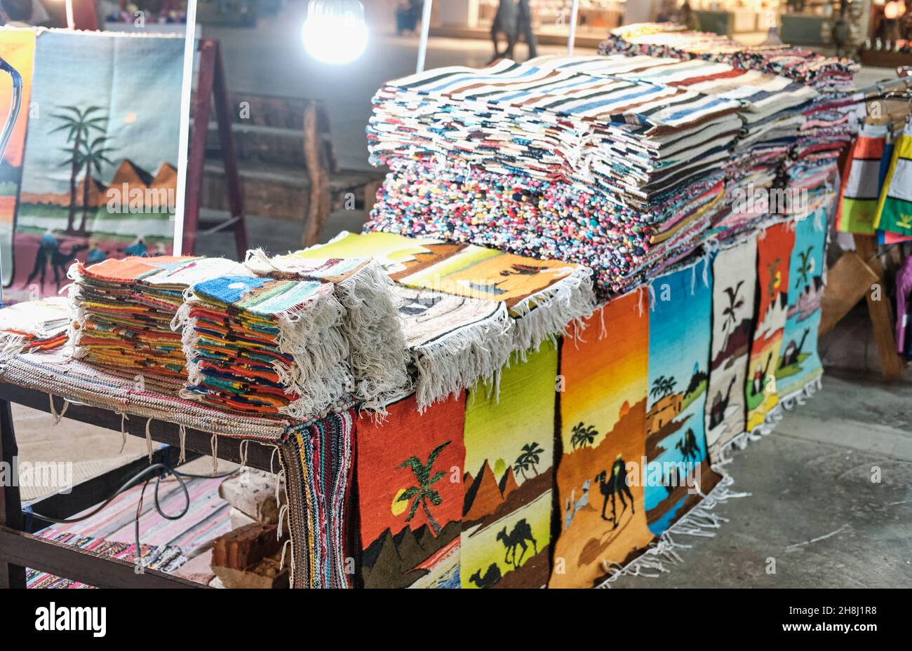 Handgefertigte kleine bunte Teppiche mit Bildern von Palmen und Kamelen als touristische Souvenirs Stockfoto