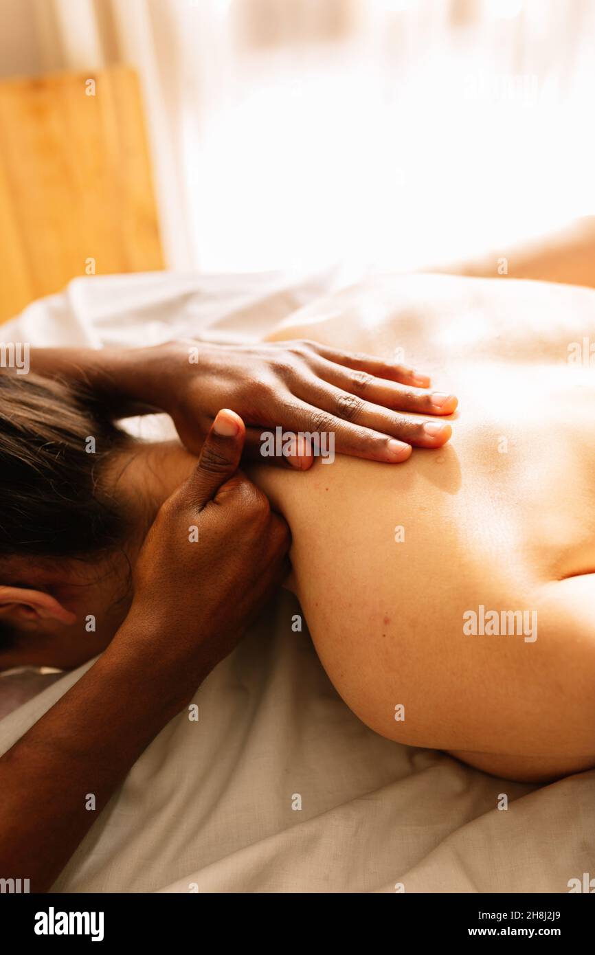 Hände eines afroamerikanischen professionellen Therapeuten, der eine Massage gibt Stockfoto