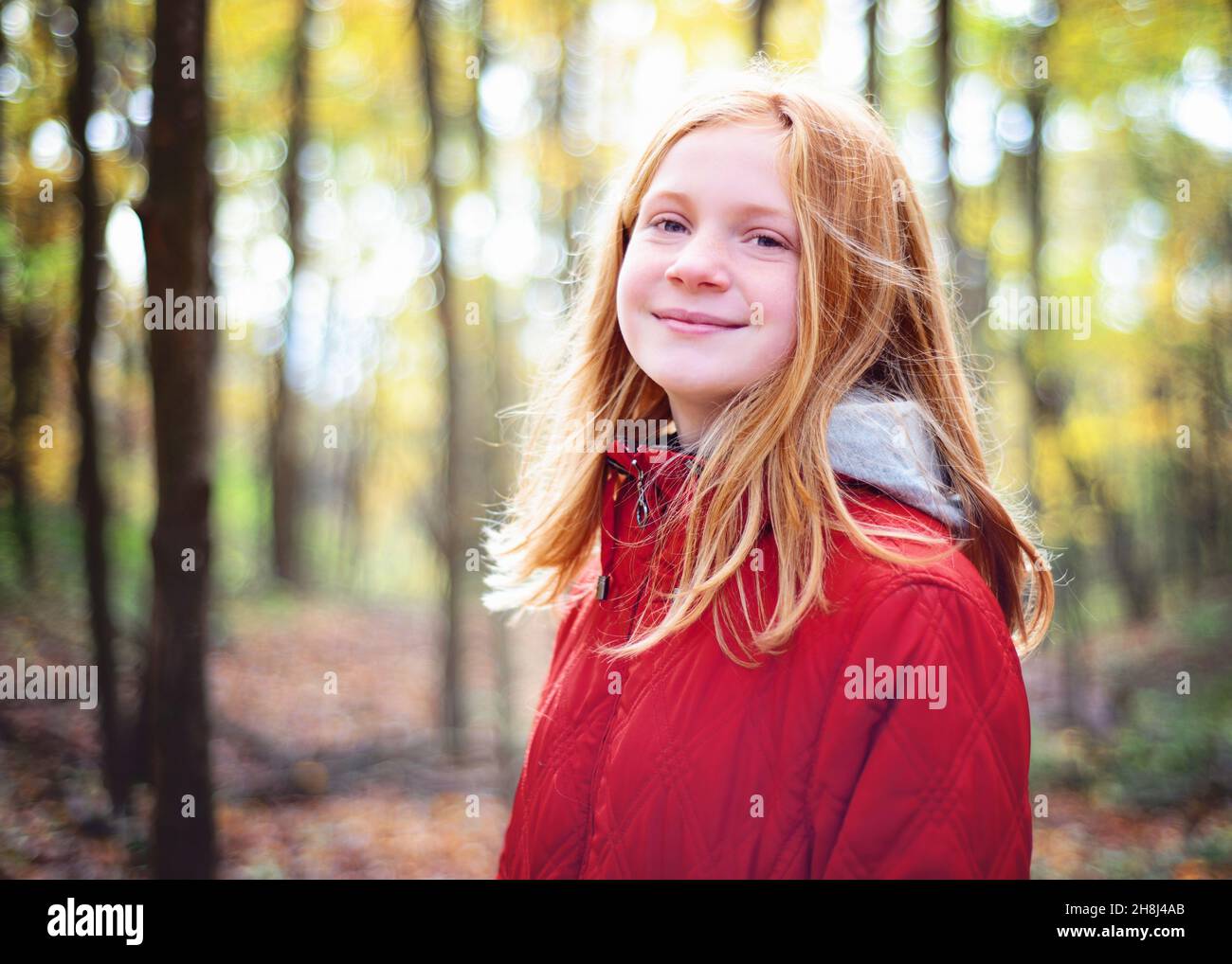 Rothaarige Tween Girl Wandern in den Herbstwäldern. Stockfoto