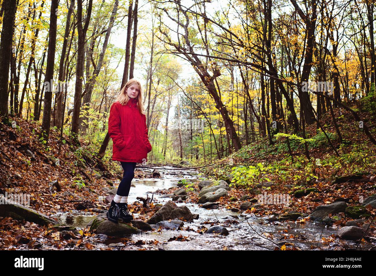 Rothaarige Tween Girl Wandern in den Herbstwäldern. Stockfoto