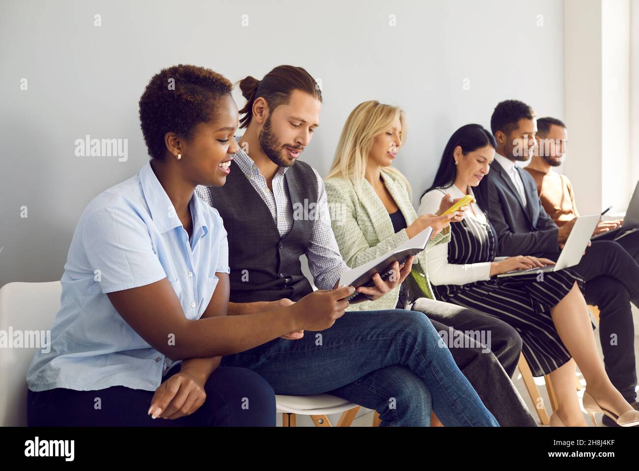 Multirassische Leute warten in der Schlange für Interview im Büro Stockfoto