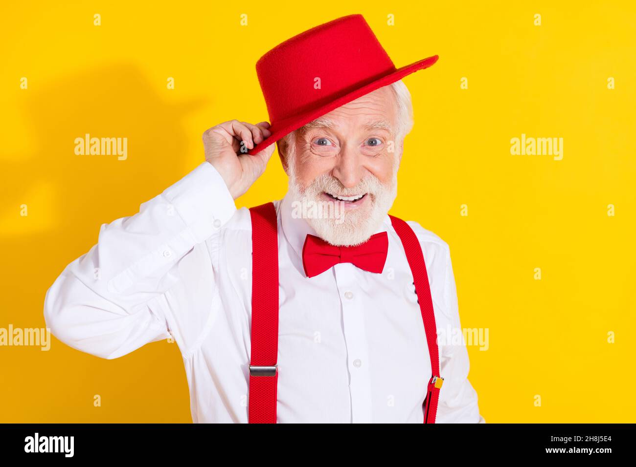 Foto von cool gealterten Mann Kleid rote Mütze tragen Krawatte Hemd Hosenträger Hose isoliert auf gelbem Hintergrund Stockfoto