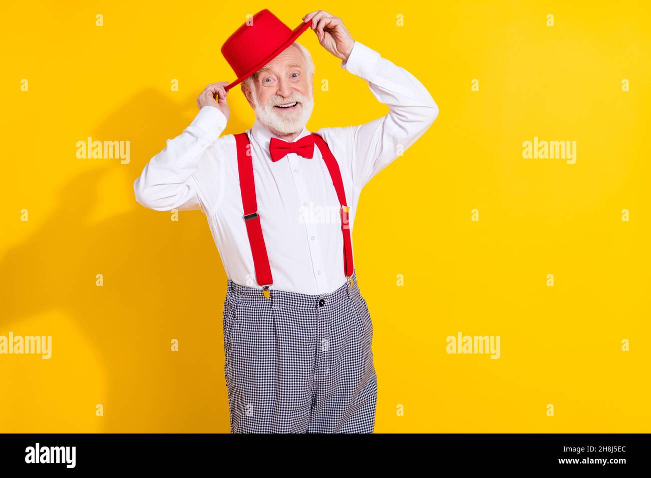 Foto von cool gealterten Mann versuchen neue Mütze tragen Krawatte Hemd Hosenträger karierte Hose auf gelbem Hintergrund isoliert Stockfoto