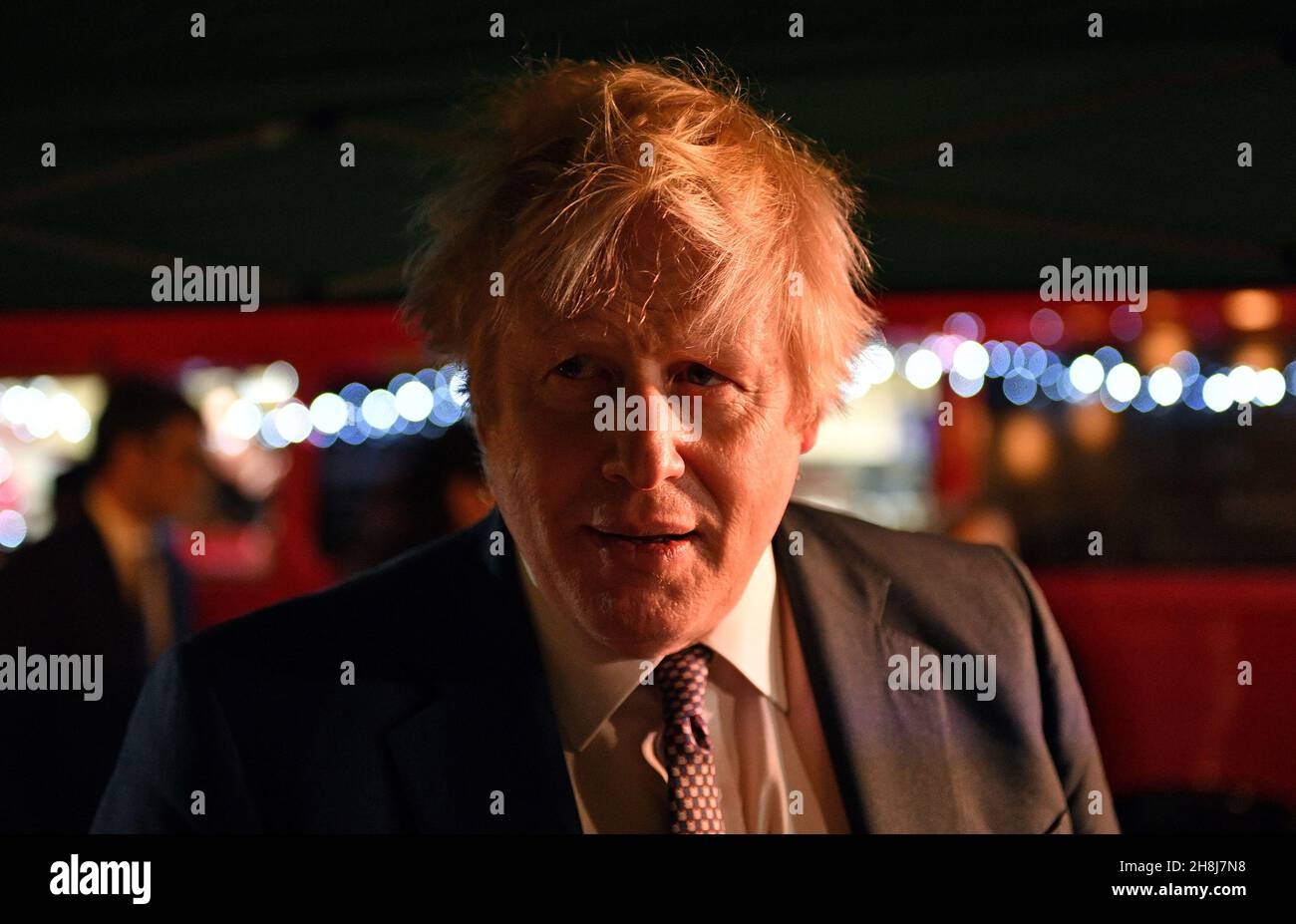 Premierminister Boris Johnson reagiert darauf, als er mit Standbesitzern spricht, während er einen britischen Lebensmittel- und Getränkemarkt besucht, der in der Downing Street, London, eingerichtet wurde. Bilddatum: Dienstag, 30. November 2021. Stockfoto