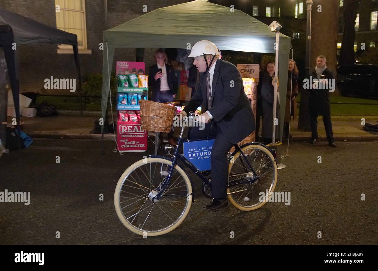 Premierminister Boris Johnson auf einem Fahrrad, als er einen britischen Lebensmittel- und Getränkemarkt besucht, der in der Downing Street in London eingerichtet wurde. Bilddatum: Dienstag, 30. November 2021. Stockfoto