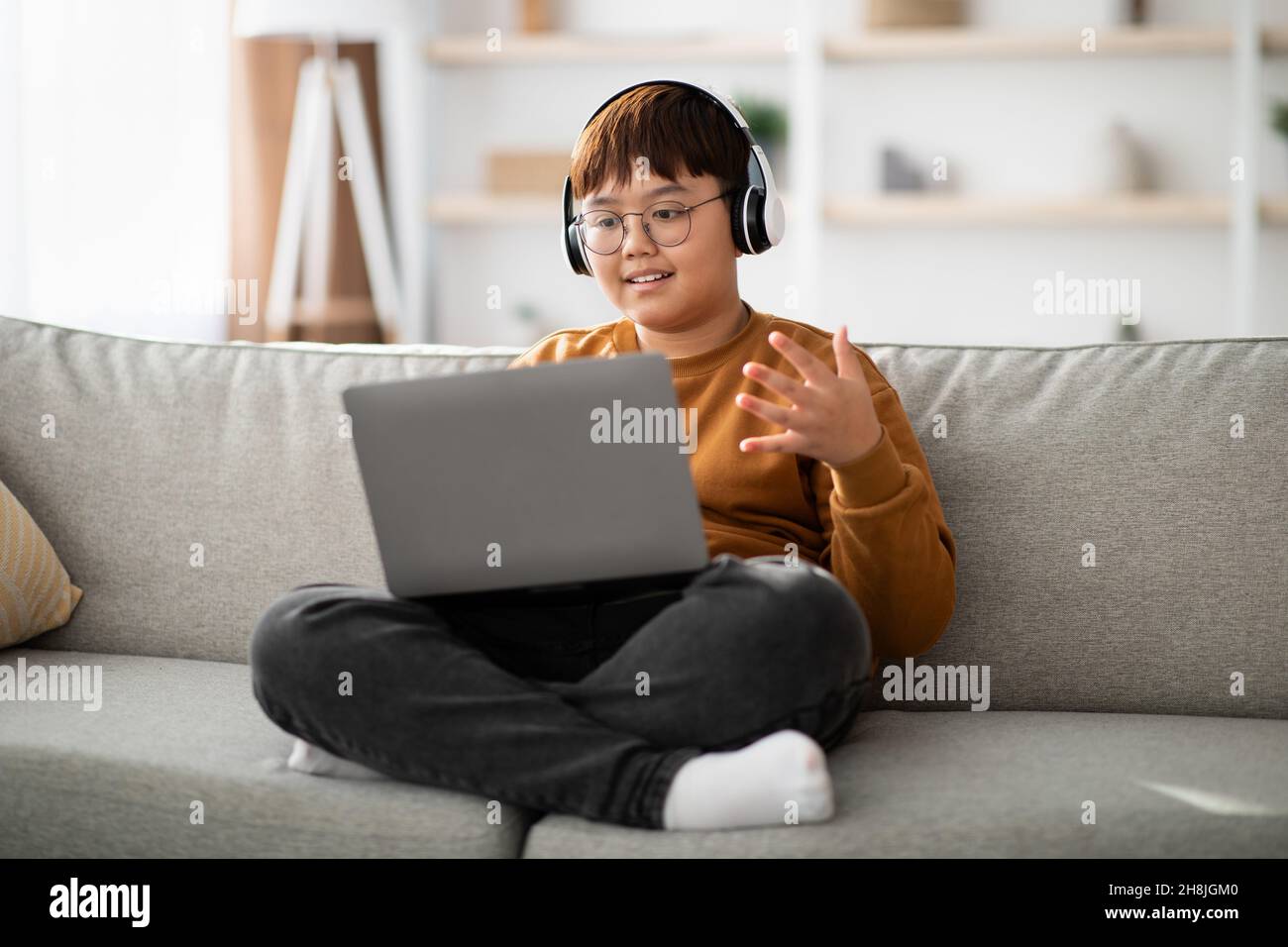Mollige asiatische Kind mit Laptop zu Hause, mit Videoanruf Stockfoto