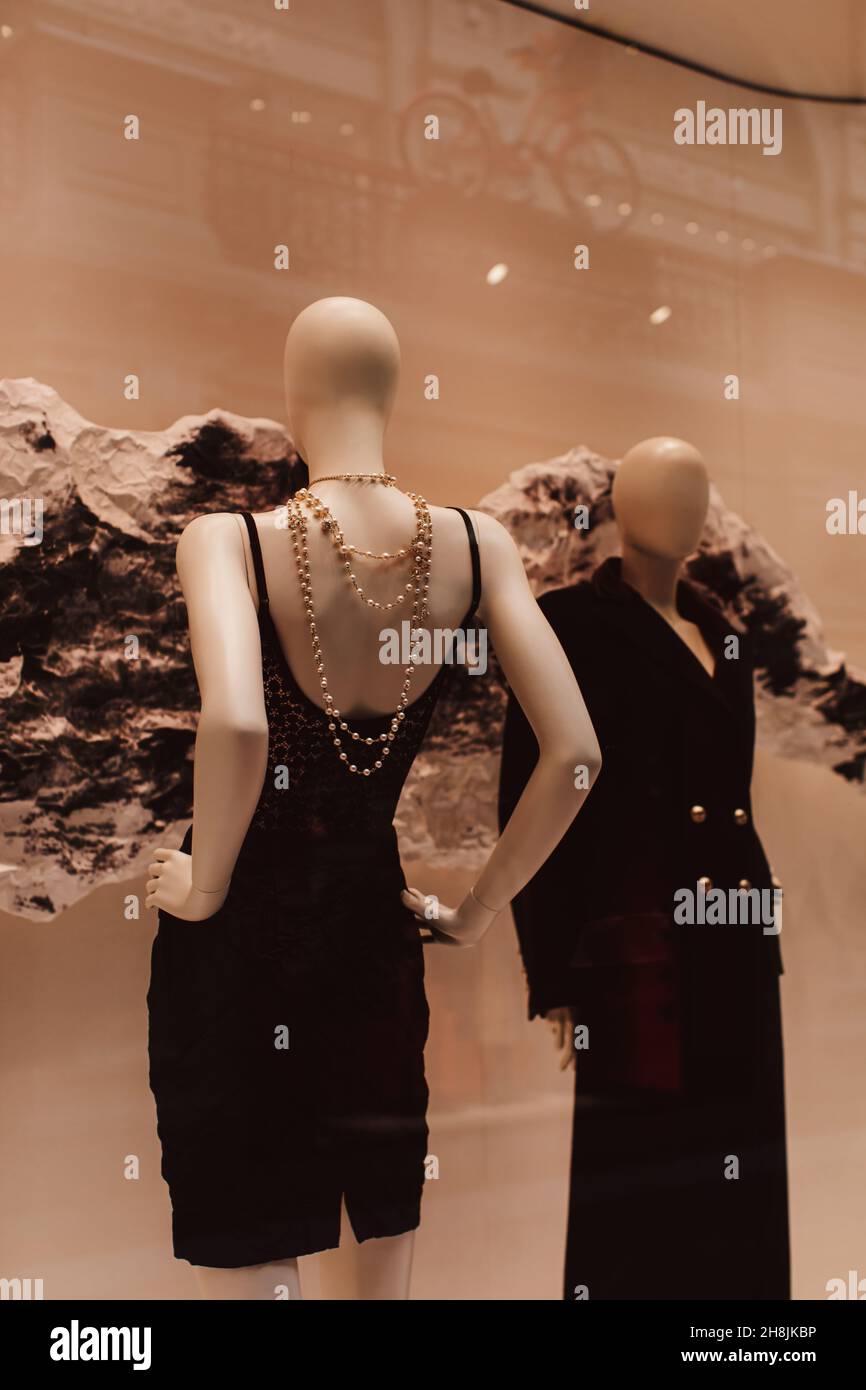 Zwei Modefiguren in eleganten schwarzen Outfits und Perlen. Herbst-Winter-Modekollektion im Schaufenster. Vertikal Stockfoto