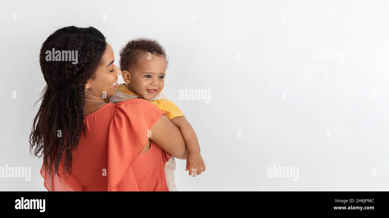 Mutters Liebe. Afroamerikanische Frau Posiert Mit Niedlichem Kleinen Baby Auf Den Händen Stockfoto