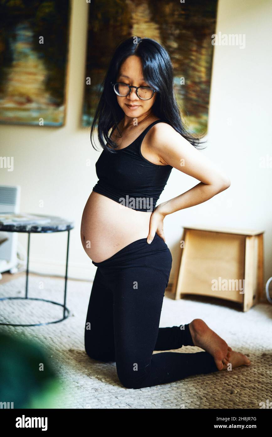 Schwangere Frau Ausübung im Wohnzimmer Stockfoto