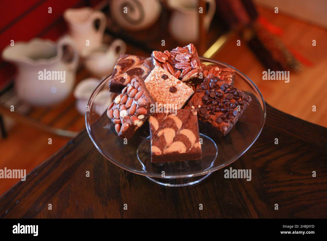 Stapel Brownies auf Glasplatte auf Holztisch in Zimmereinstellung Stockfoto