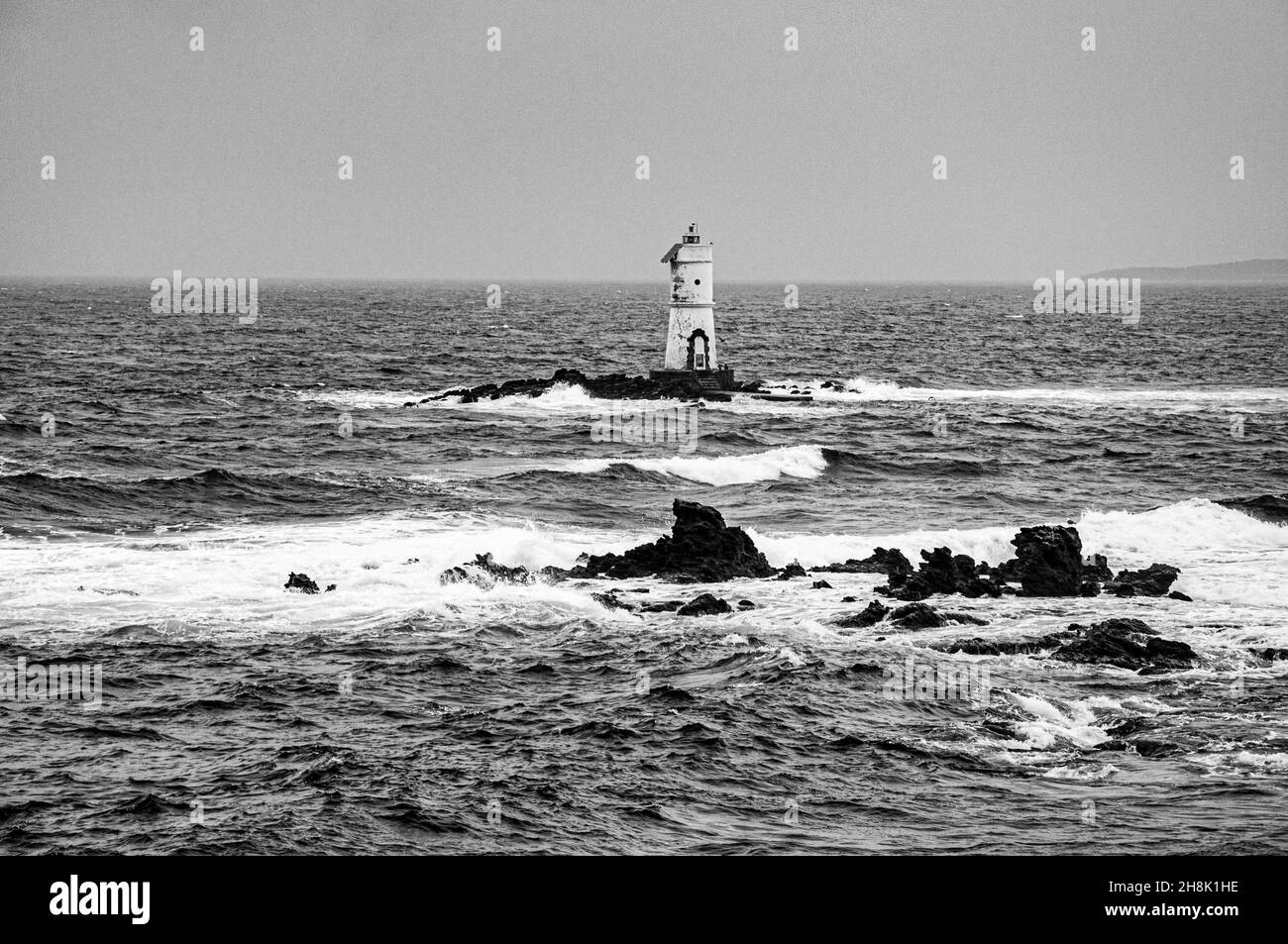 Schöne Aussicht auf einen alten Leuchtturm im welligen Meer Stockfoto