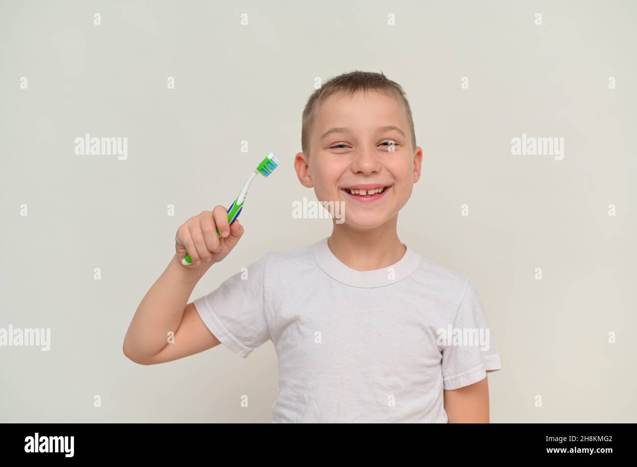 Ein lächelnder Junge hält eine Zahnbürste in der Hand Stockfoto