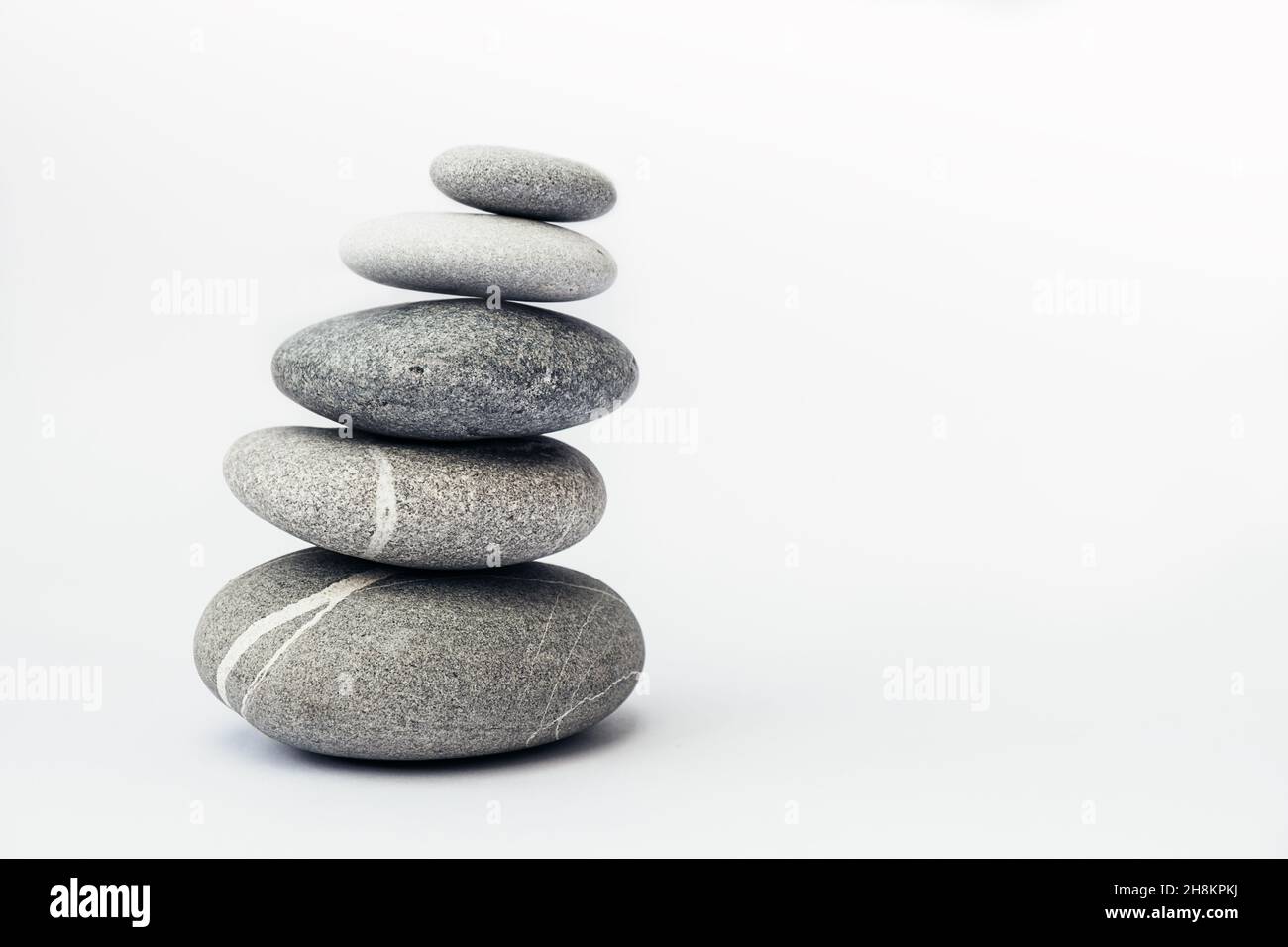 Steinkairn auf hellem Hintergrund, Steinturm, einfache Gelassenheit Steine. Reinheit Harmonie und Balance Konzept. Für Text platzieren. Stockfoto