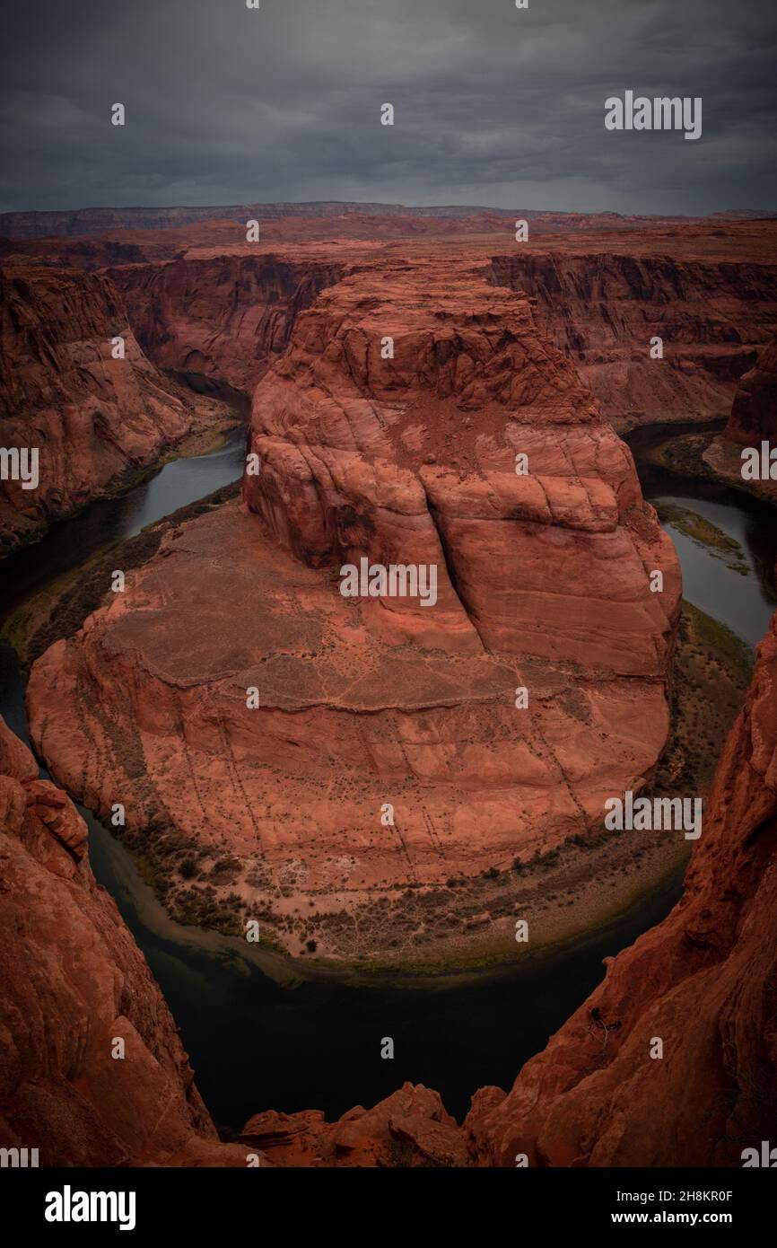 Blick auf das Horseshoe Bend, ein hufeisenförmiges, eingeschnitztes Mäander des Colorado River, Sturmwolken am Himmel, Page, Arizona, USA Stockfoto