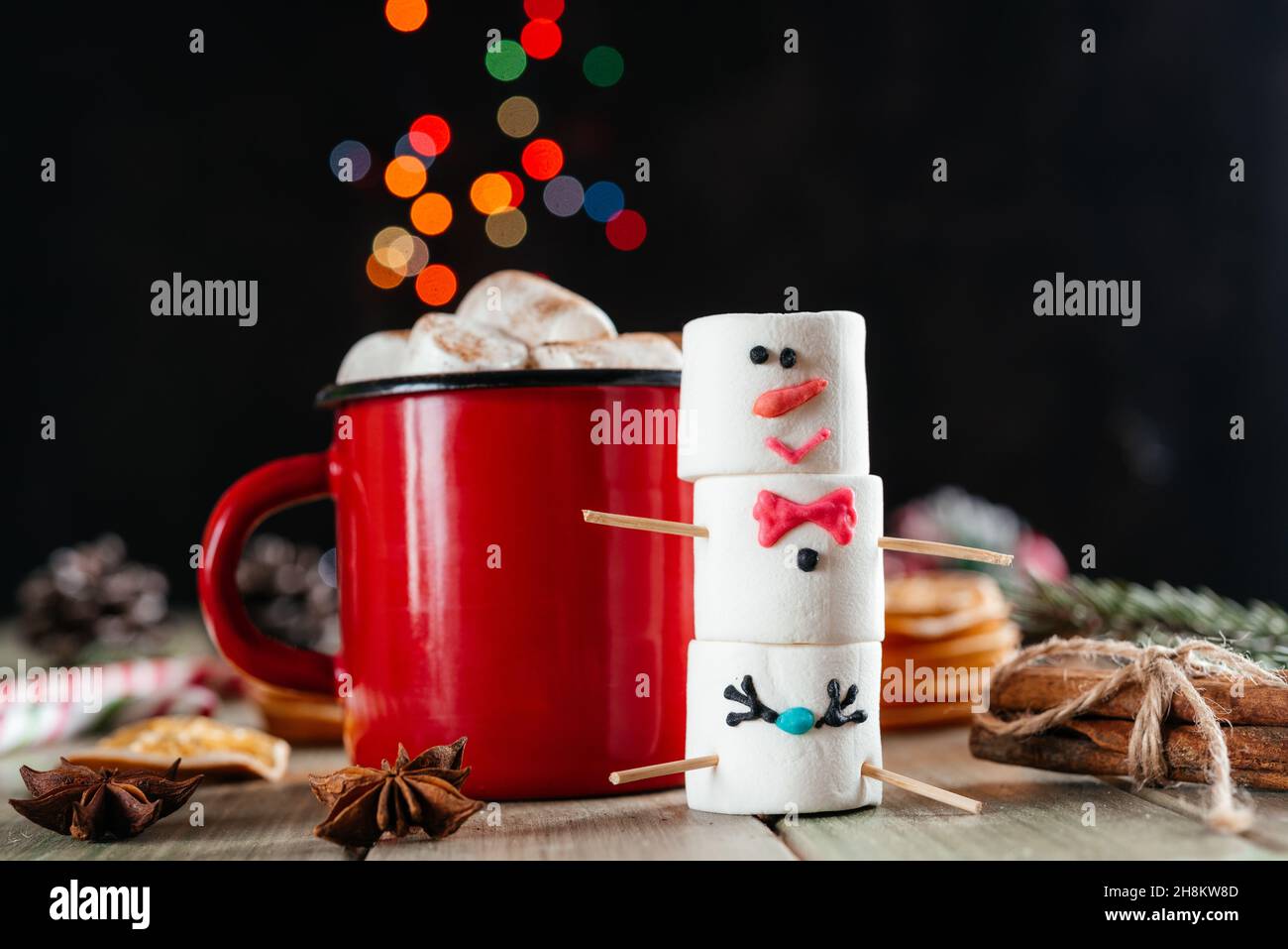 Rote emaillierte Tasse mit heißer Schokolade und Schneemann auf Weihnachtshintergrund Stockfoto